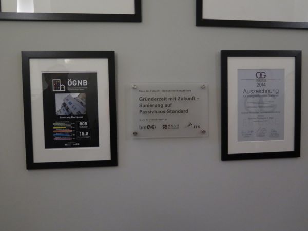 „Haus der Zukunft“-Plakette, Urkunde der ÖGNB und weitere Auszeichnungen im Gangbereich des Wohnhauses in der Eberlgasse