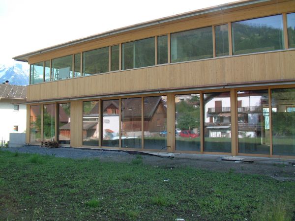 Zahlreiche Fenster an der Seitenwand des Holzbaus Gemeindezentrum Ludesch