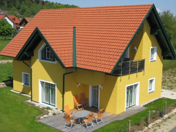 Gelbes Passivhaus mit Vorbau und Garten 