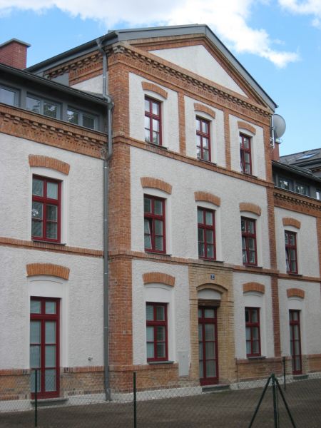 Weiße Fassade der Arbeiterwohnanlage Felixdorf nach der Sanierung