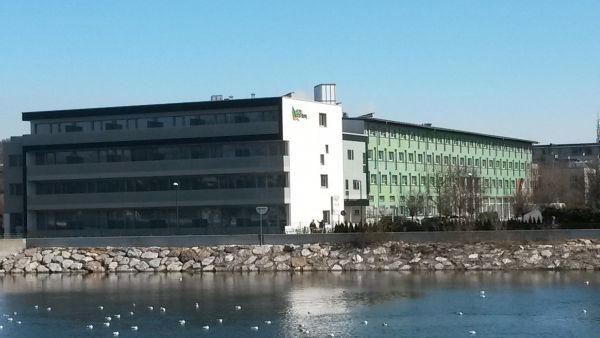 Das Bild zeigt das Eco-Suite-Hotel und dahinter das Kolpinghaus, fotografiert vom gegenüberliegenden Ufer der Salzach
