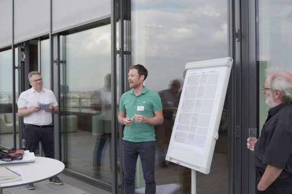 Hannes Warmuth hält einen Vortrag auf einer Terrasse eines Gebäudes