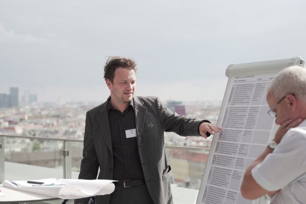 Tobias Weiß  hält einen Vortrag auf einer Terrasse eines Gebäudes
