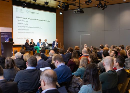 Diskutierende Menschen auf dem Podium und Publikum