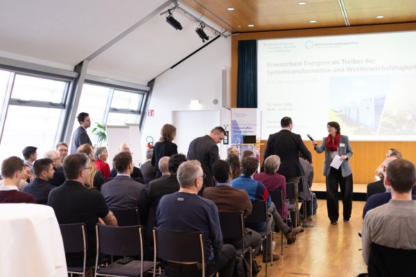 Die Moderatorin befragt Personen aus dem Publikum