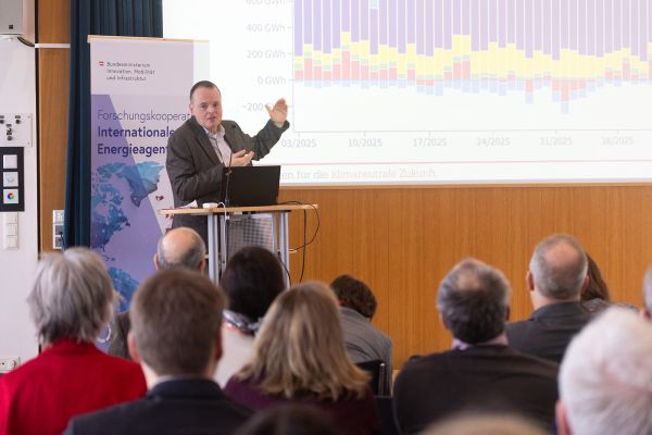 Vortragender auf dem Podium vor Publikum im Saal