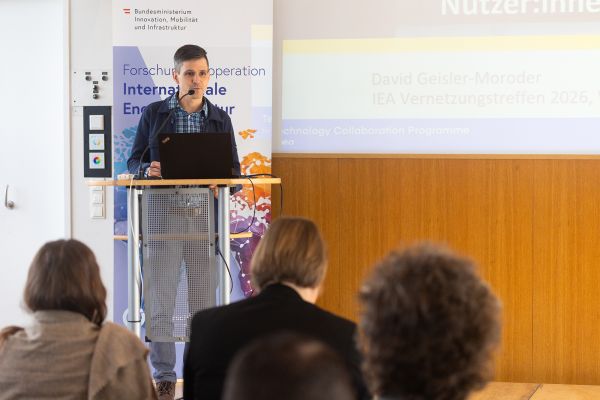 Vortragender auf dem Podium vor Publikum im Saal