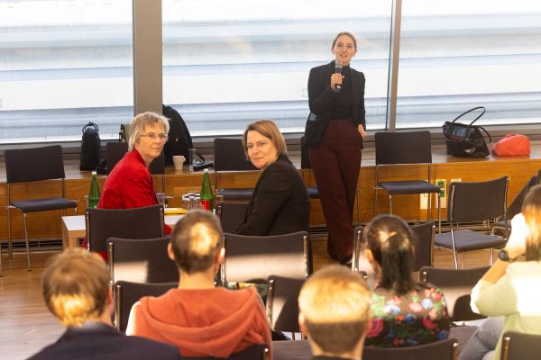 Vortragende steht vor Publikum und spricht in ein Mikrofon