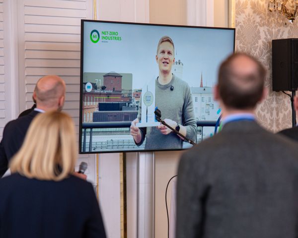 Drei Personen schauen auf einen Bildschirm