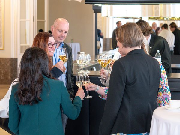 Mehrere Personen stoßen mit Sektgläsern an.