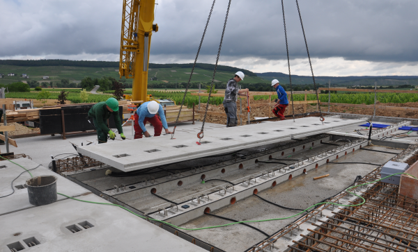 Vorgefertigte CEILTEC-Flachdecke mit Sandwich-Querschnitt, getrennten oberen und unteren Platten sowie einem Hohlraum auf der Baustelle während der Umsetzung.